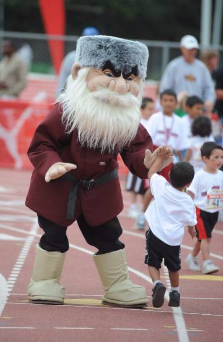 Mascot Joe Mountie high fives a child during the munchkin run.
